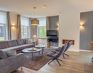 Moderne eetruimte in Dune Design vakantiehuis, Colijnsplaat, met open haard en flatscreen TV.