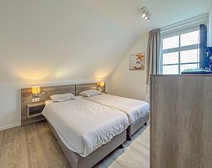 Lichte slaapkamer met TV in Dune Design vakantiehuis, Colijnsplaat, Noord-Beveland.