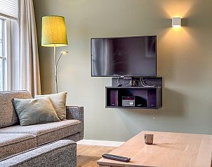 Moderne woonkamer in Villa Superieur 64, Colijnsplaat, met flatscreen TV en comfortabele banken in Zeeland.