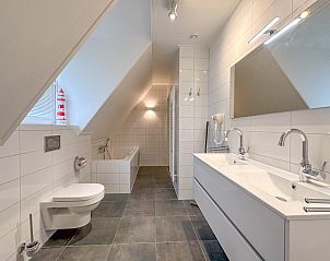 Ruime badkamer in Villa Superieur 64, Colijnsplaat, met dubbele wastafel en bad in vakantiehuis, Zeeland.