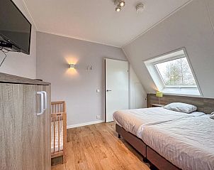 Derde slaapkamer in Villa Superieur 64, Colijnsplaat, met kinderbedje en TV in vakantiehuis, Zeeland.