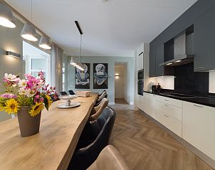 Stijlvolle eetkamer met bloemen in Villa Aqua de Luxe, vakantiehuis in Colijnsplaat, Zeeland.