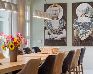Sfeervolle eetruimte met kunst in Villa Aqua de Luxe, vakantiehuis in Colijnsplaat, Zeeland.