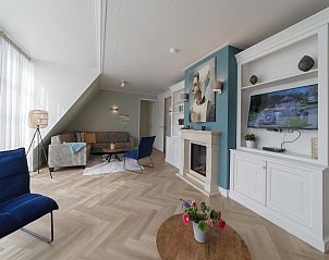 Gezellige woonkamer in Villa Aqua de Luxe, vakantiehuis in Colijnsplaat, Zeeland met open haard.