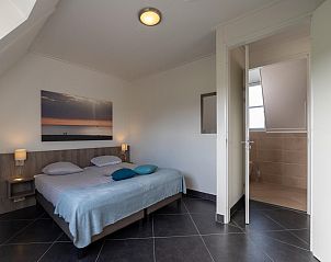 Comfortabele slaapkamer in Villa Aqua de Luxe, vakantiehuis in Colijnsplaat, Zeeland met ensuite badkamer.