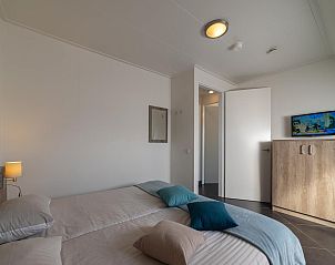 Slaapkamer met televisie in Villa Aqua de Luxe, vakantiehuis in Colijnsplaat, Zeeland.