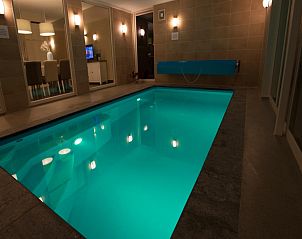 Verlicht zwembad in Villa Aqua de Luxe, vakantiehuis in Colijnsplaat, Zeeland voor avondzwemmen.