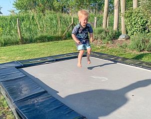 Kind speelt op trampoline in de tuin van Villa Aqua de Luxe, vakantiehuis in Colijnsplaat, Zeeland.
