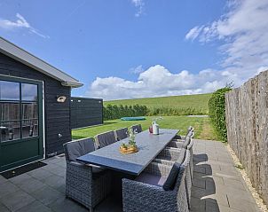 Gezellig terras bij Samen aan Zee vakantiehuis in Colijnsplaat, Noord-Beveland, met uitzicht op groene omgeving.