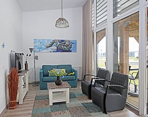 Gezellige woonkamer van Bungalow de Dukdalf in Kamperland, met comfortabele zithoek en grote ramen.