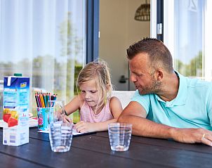Gezin geniet van creatieve activiteiten op het terras van Bungalow de Dukdalf in Kamperland.