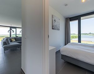 Gerumiges Wohnzimmer mit groen Fenstern im Bungalow Waterline 44, De Groote Duynen, Kamperland.