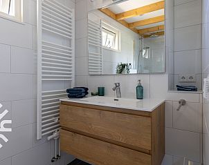 Terrasse des Ferienhauses ZE1208 in Kamperland, mit Sonnenschirm und bequemen Sthlen.