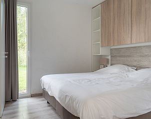 Komfortables Schlafzimmer im Bungalow de Boei, mit Blick auf den Garten in Kamperland, Noord-Beveland, Zeeland.