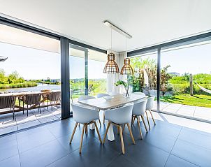 Eetkamer met uitzicht op tuin in Duinvallei 32, vakantiehuis in Kamperland, Zeeland.