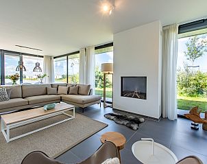 Ruime woonkamer met open haard in Duinvallei 32, vakantiehuis in Kamperland, Zeeland.