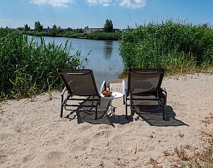 Zonnig strandje aan het water in Duinvallei 32, vakantiehuis in Kamperland, Zeeland.