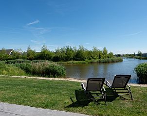 Terras aan het water met parasol in Duinvallei 32, vakantiehuis in Kamperland, Zeeland.