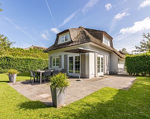 Villa R8B in Kamperland, North Beveland offers a charming vacation home with thatched roof and sun-drenched terrace in green surroundings.