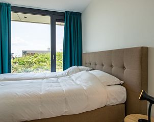 Slaapkamer met uitzicht op tuin in Waterlijn 25 | De Groote Duynen, vakantiehuis in Kamperland, Noord-Beveland.