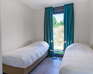 Kleine slaapkamer in Waterlijn 25 | De Groote Duynen, vakantiehuis in Kamperland, Noord-Beveland, met twee bedden en raam.