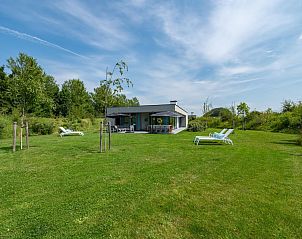 Ruime tuin bij Waterlijn 25 | De Groote Duynen, vakantiehuis in Kamperland, Noord-Beveland, met ligstoelen en groen landschap.