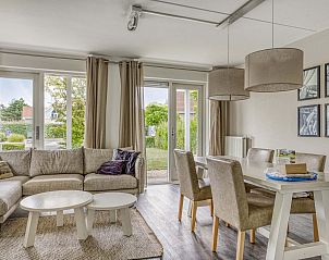 Gezellige woonkamer van vrijstaande woning in Kamperland, Noord-Beveland, Zeeland, met uitzicht op groene tuin en comfortabele zithoek.