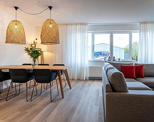 Zonnige woonkamer met grote ramen in VZ2408 Vakantieappartement, Kamperland, Noord-Beveland, Zeeland.