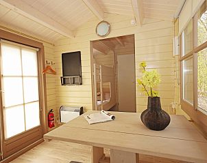 Stijlvolle binnenruimte van Kampeerchalet het Gangboord in Kamperland, Noord-Beveland, met een gezellige eettafel en natuurlijke lichtinval.