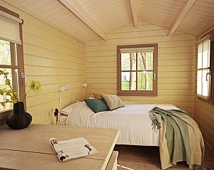 Comfortabele slaapkamer in Kampeerchalet het Gangboord, Kamperland, Noord-Beveland, met uitzicht op de groene omgeving.