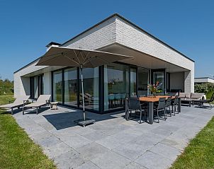 Terras van Duinvallei 39 in De Groote Duynen, Kamperland, met comfortabele ligstoelen en een eettafel.