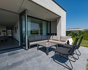 Veranda van Duinvallei 39, De Groote Duynen, Kamperland, met een comfortabele zithoek en tuinzicht.