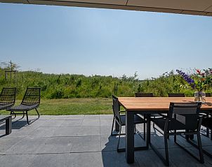 Buitenruimte van Duinvallei 39, De Groote Duynen, Kamperland, met een eettafel en uitzicht op de natuur.