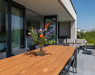 Bloemen op de tafel van het terras in Duinvallei 39, De Groote Duynen, Kamperland, met uitzicht op de tuin.
