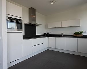Moderne keuken in Duinvallei 39, De Groote Duynen, Kamperland, met strakke witte kasten en apparatuur.