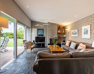 Gezellige woonkamer in Berkenlaan 6 | Ruiterplaat, vakantiehuis in Kamperland, Zeeland met uitzicht op de tuin.