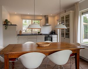 Gezellige eetkamer in Vinkenlaan 8 | De Banjaard, Kamperland, met uitzicht op de groene tuin in Noord-Beveland.