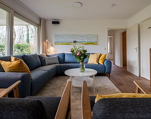 Comfortabele zithoek in vakantiehuis Vinkenlaan 8 | De Banjaard, Kamperland, met grote ramen en veel licht.