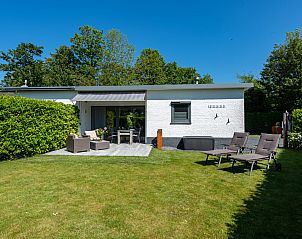 Auenansicht des Ferienhauses Patrijzenlaan 5, De Banjaard in Kamperland, umgeben von viel Grn und einer sonnigen Terrasse.