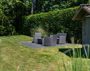 Sitzecke im Garten des Hauses Patrijzenlaan 5, De Banjaard, Kamperland, umgeben von Grnanlagen.