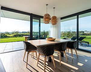 Eetkamer in Duinvallei 43, vakantiehuis in Kamperland, Noord-Beveland, met uitzicht op groene natuur.