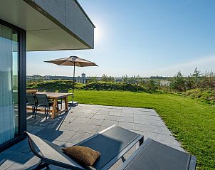 Zonnig terras van Duinvallei 43, vakantiehuis in Kamperland, met ligstoelen en uitzicht op het landschap.