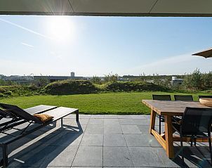 Groot terras bij Duinvallei 43, vakantiehuis in Kamperland, met eettafel en ligstoelen voor ontspanning.