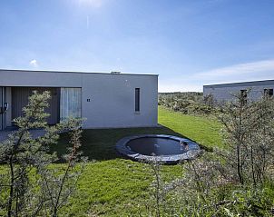 Moderne bungalow Duinvallei 43 in Kamperland, Noord-Beveland, met trampoline en groen landschap.