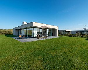 Achterzijde van Duinvallei 43, vakantiehuis in Kamperland, met groot terras en groene tuin.