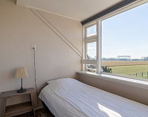 Eenpersoonsbed met uitzicht in Vakantiehuisje in Kamperland, Noord-Beveland, omgeven door Zeeuwse natuur.