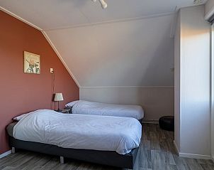 Slaapkamer met twee bedden in Vakantiehuisje in Kamperland, Noord-Beveland, Zeeland, met warme inrichting.