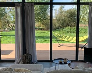 View from living room cottage Kamperland, with terrace and green surroundings in Zeeland.
