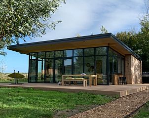 Moderne vakantiehuis in Kamperland met glazen gevels en houten terras, gelegen op Noord-Beveland, Zeeland.