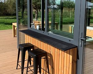 Buitenterras van vakantiehuis Kamperland met moderne bar en zitplaatsen, gelegen in Noord-Beveland, Zeeland.